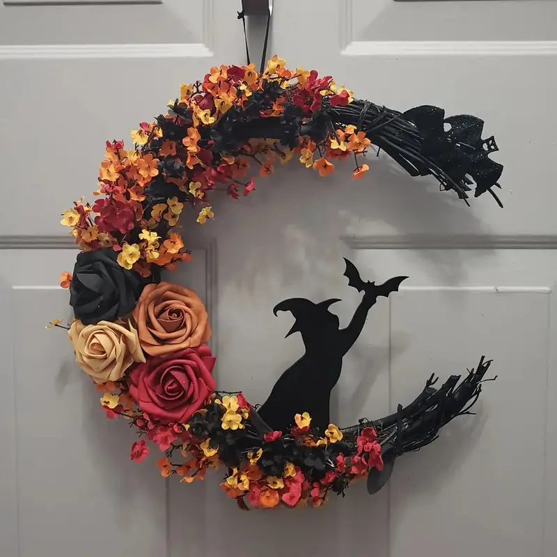 Deurkrans in maanvorm – herfstbloemen met donker heksenfiguur