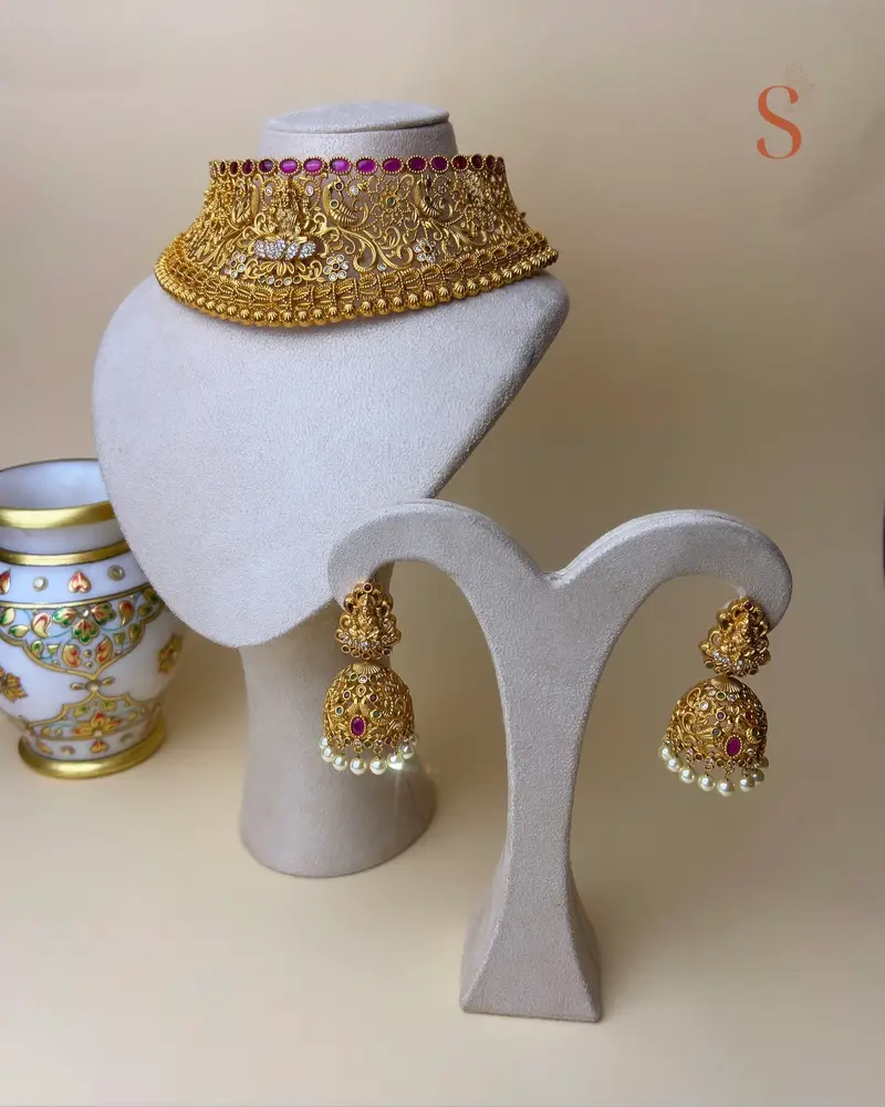 Goudkleurige grote sieradenset met de afbeelding van godin Lakshmi en roze stenen