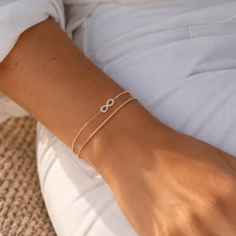 Rosé gold plated zilveren infinity armband met steentjes