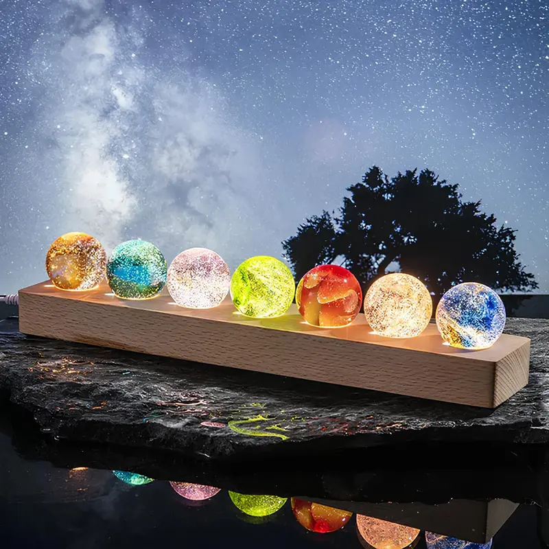 Sfeerlamp – zeven glazen bollen met sterrenstelsels op houten voet