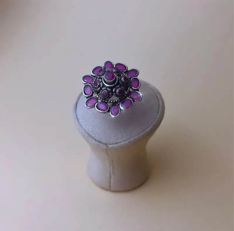 Zilverkleurige ring met donkerroze stenen