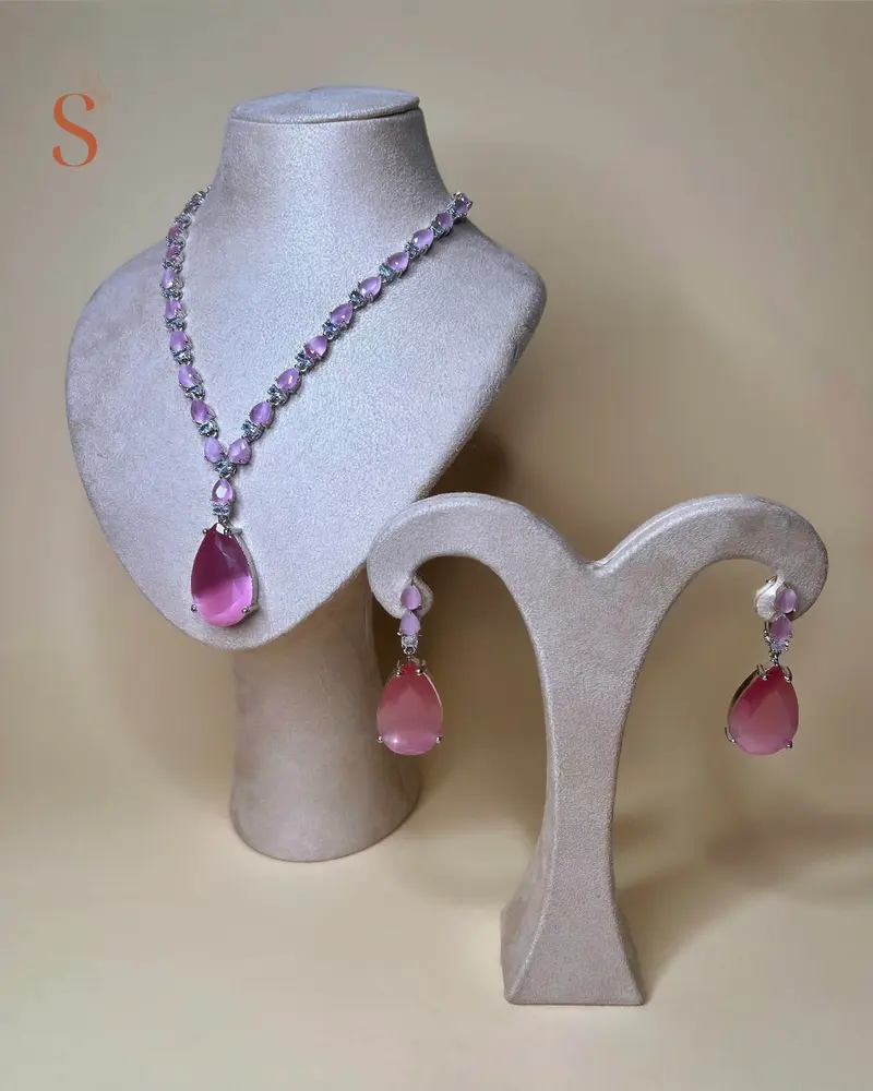 Zilverkleurige sieradenset met druppelvormig roze pendant en bewerkt collier